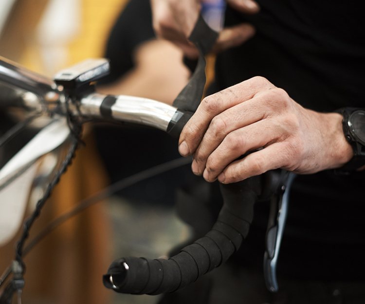 Bike Technician wrapping road bike handlebars with new tape