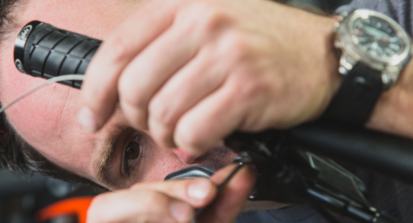 A bike mechanic replaces a shifter cable