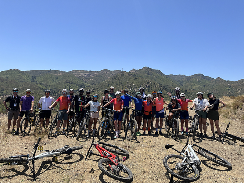 Group photo of the monthly ride group in front of a mountain range.