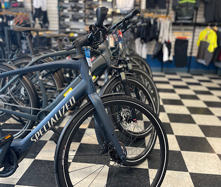 Six Specialized Vado E-bikes lined up on the retail floor.