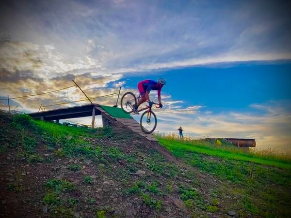 Cyclocross racer jumping over an obstacle.