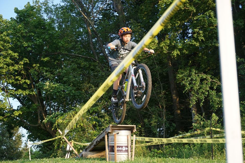 Mountain biker riding over an obstacle.