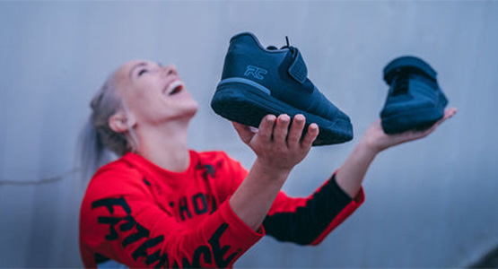 Smiling woman holding a pair of Ride Concepts Shoes