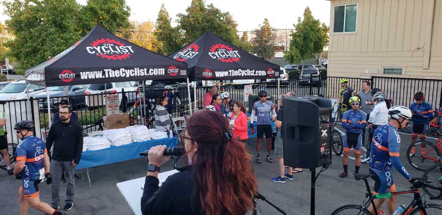 woman speaking to cyclists at charity event