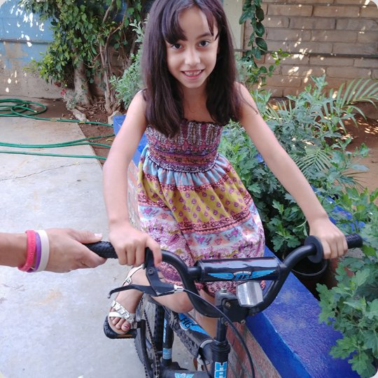 little girl in dress on black kids bike