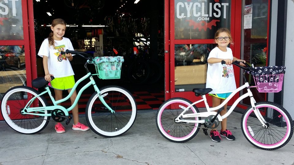 Two girls with cruiser bikes and baskets