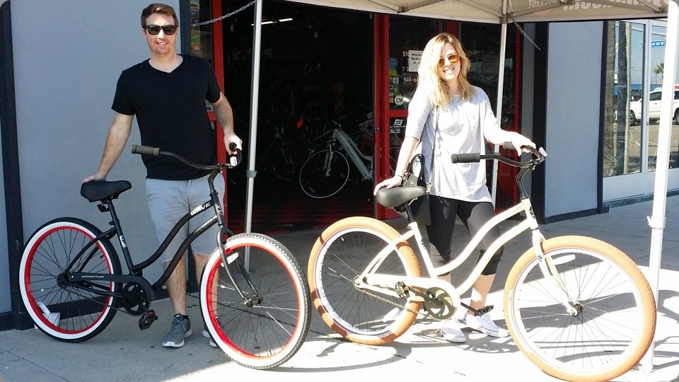 man and woman with black and white cruiser bikes