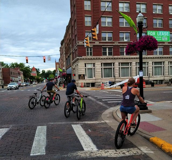 Group of riders riding around town 