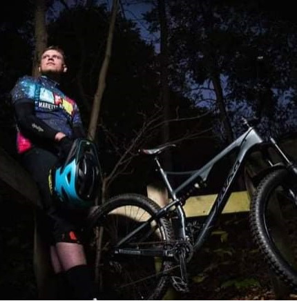 Man posing in the night with a mountain bike