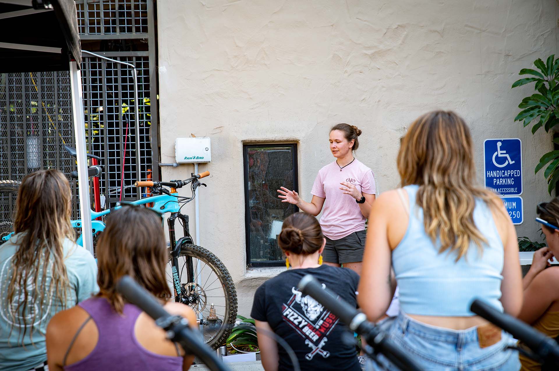Bree Duffy stands next to a Kona Process 153 in front of a group of women from the mountainadoras