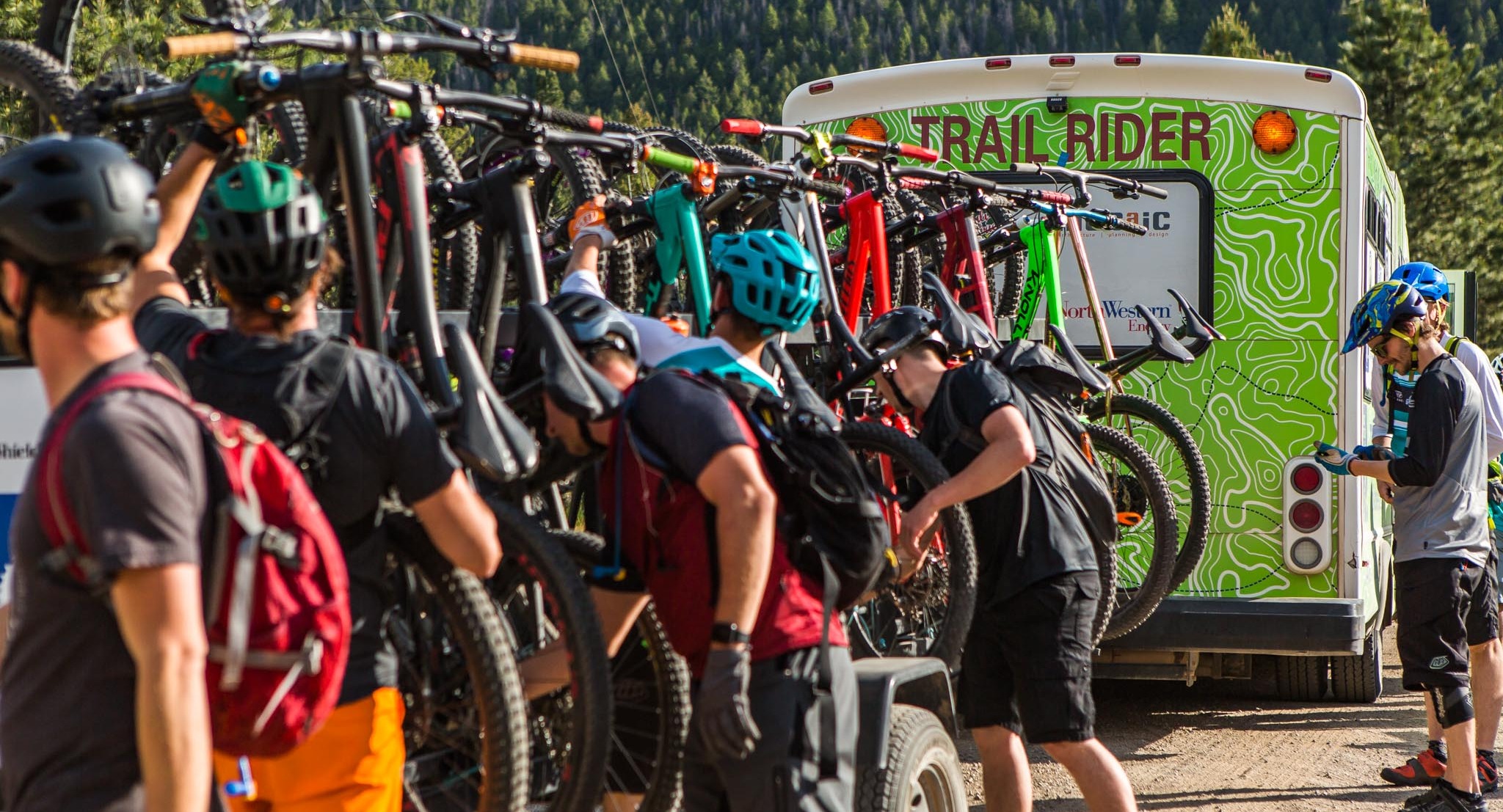 Riders loading bikes onto a trailer.
