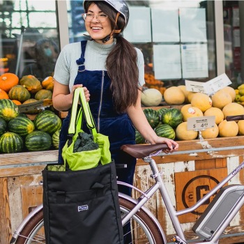 A woman putting groceries in her bike bag