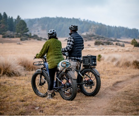 Two people on ebikes in a field