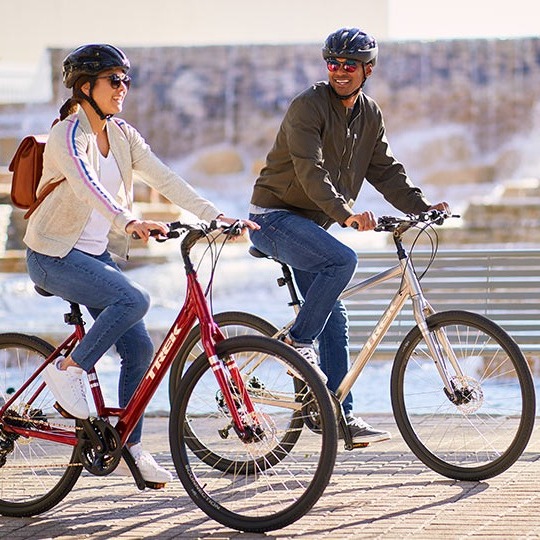 Two cyclists riding fitness/hybrid bikes