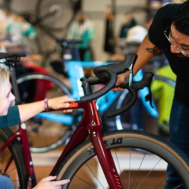 Sales person helping customer with bike