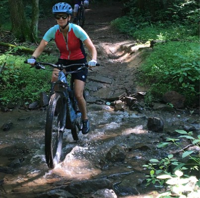 Image of a people riding mountain bikes through a creek