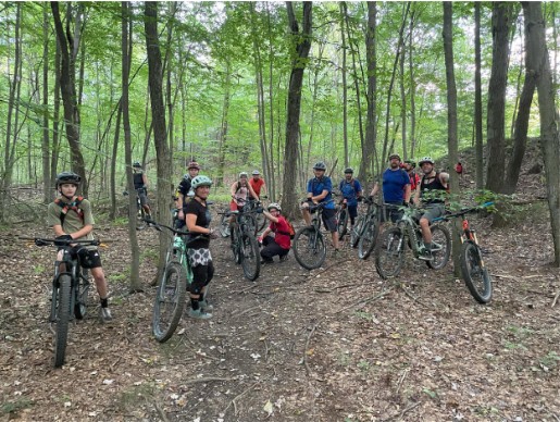 Image of DN'A Bikes group ride on mountain bikes in the woods