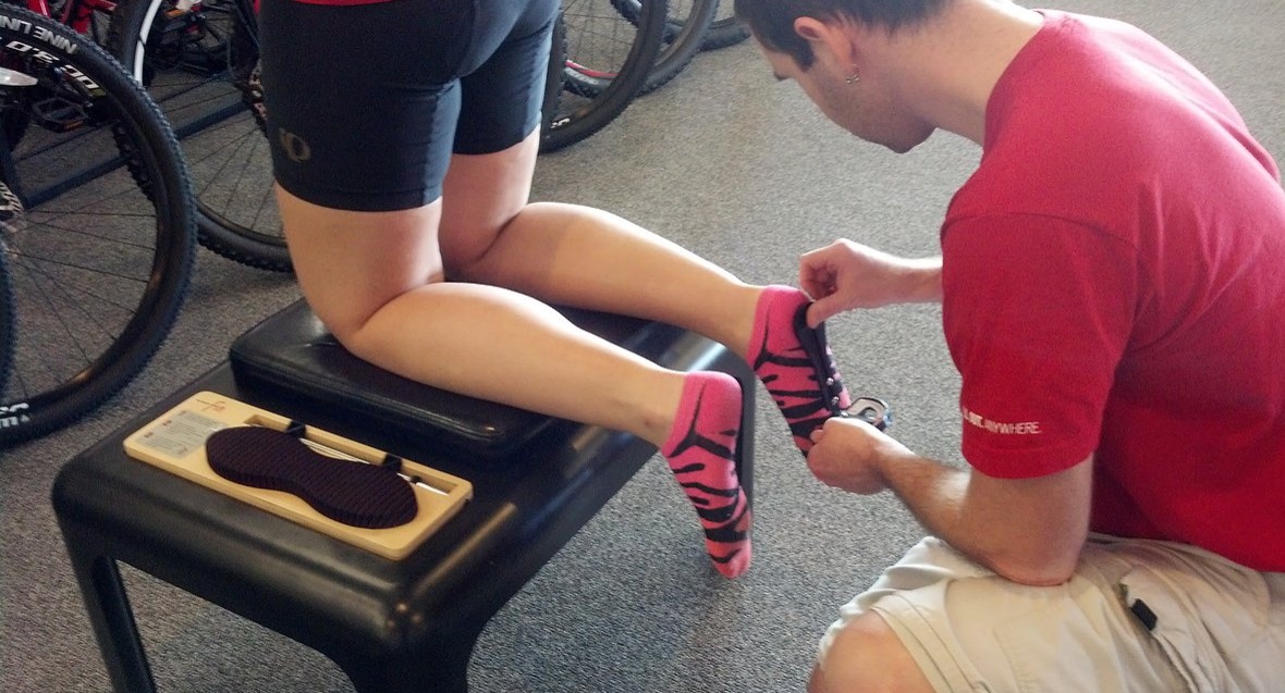 Bike Fitter measuring a cyclist feet during a fit session