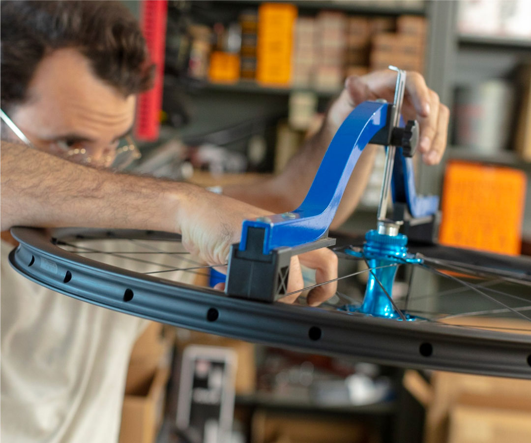 Bicycle mechanic building a custom wheel in a bike shop