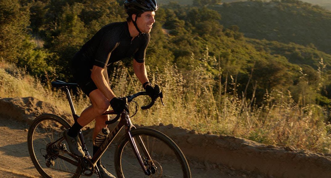 Man riding a gravel bike on a gravel trail through the mountains