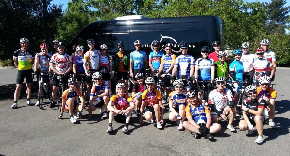 Group of cyclists in front of a tour van.