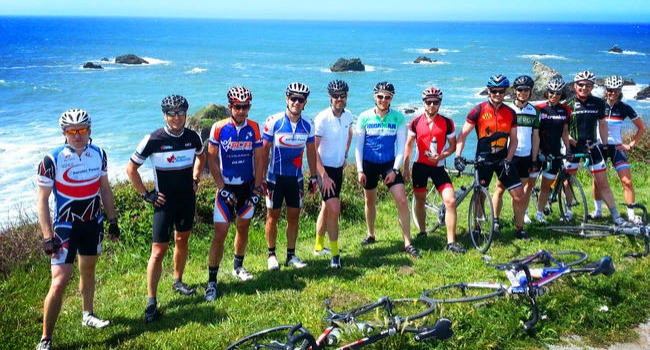 A group of cyclists taking a break on the coast.