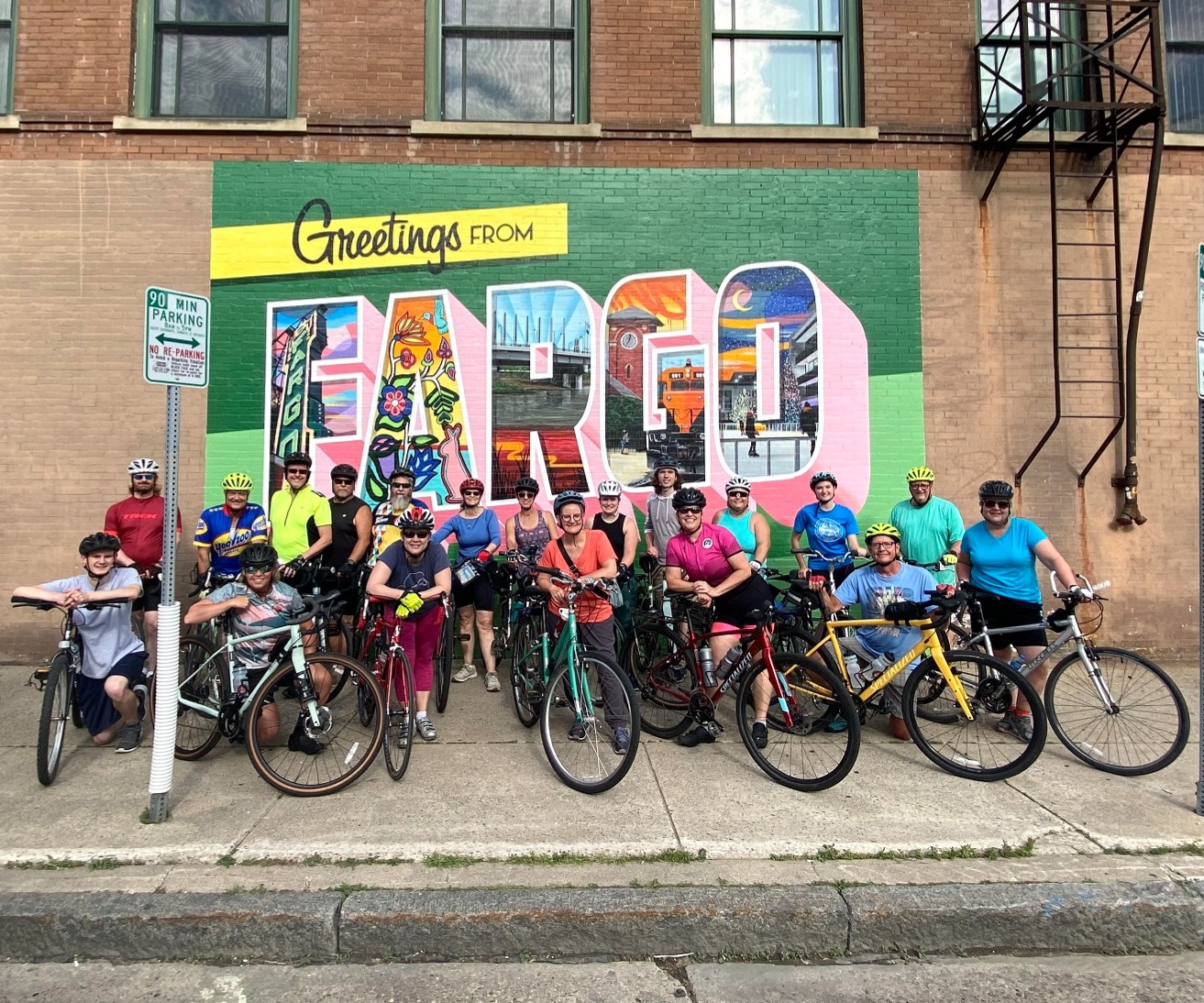 Photo of one of our group rides in front of a Fargo mural in Downtown Fargo, ND.