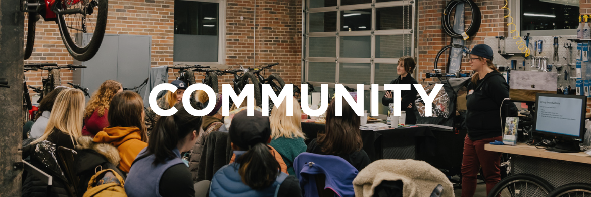 "Community" banner. Photo is of women in the bike shop.