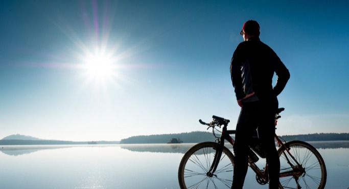 bike rider overlooking a lake near sunset with a gravel bike