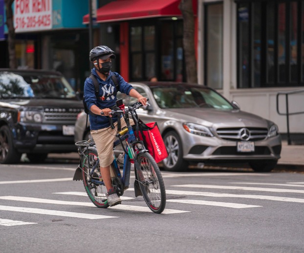 Delivery person in New York riding an e-bike