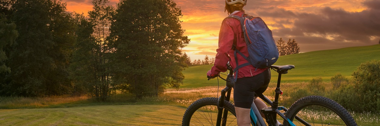 Cyclist in a field with trees at sunsight e-bike riding