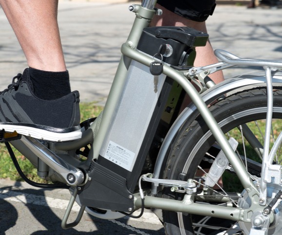 Closeup of an e-battery with a cyclist riding