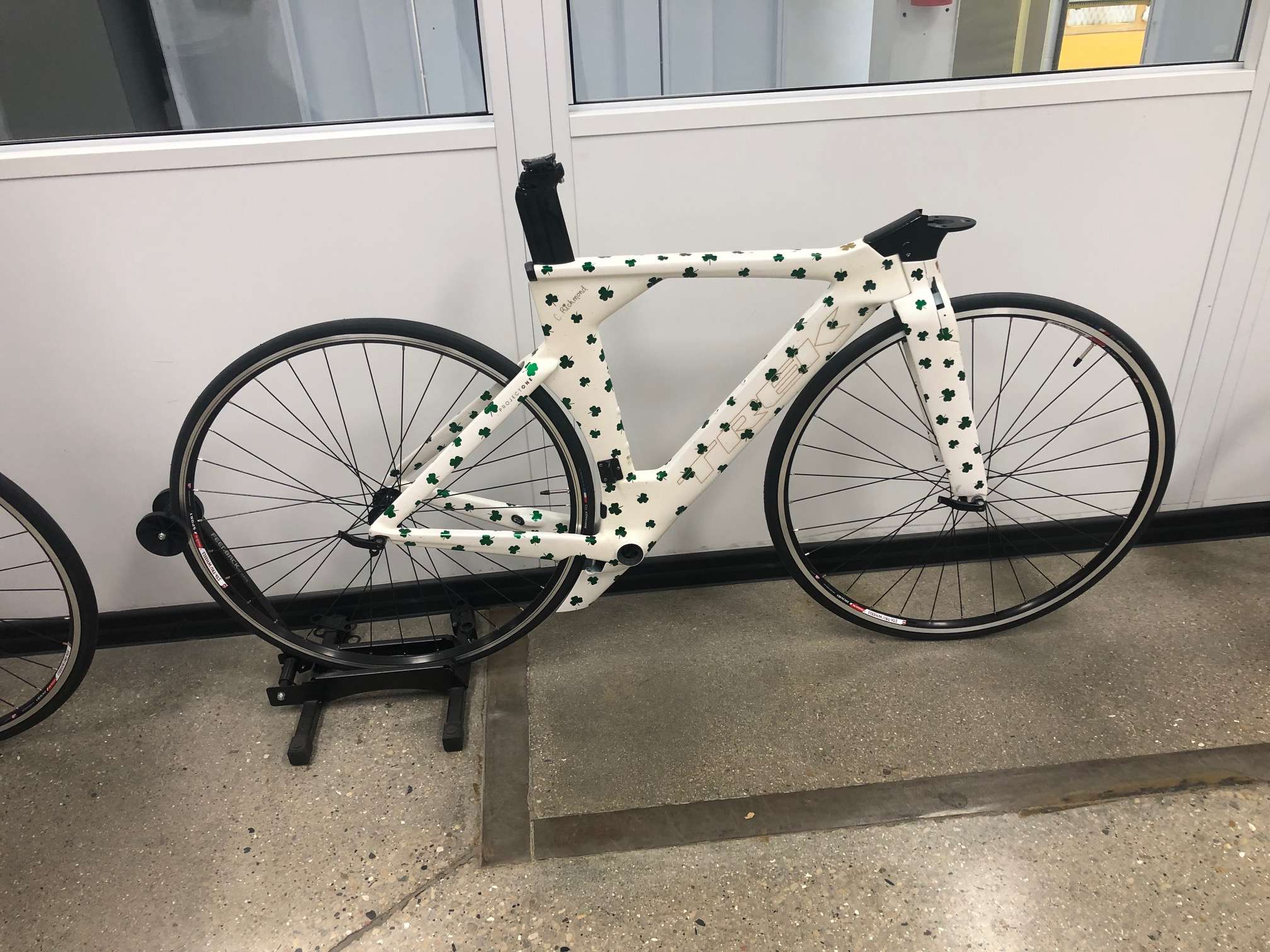 White bicycle frame with green clovers painted all over 