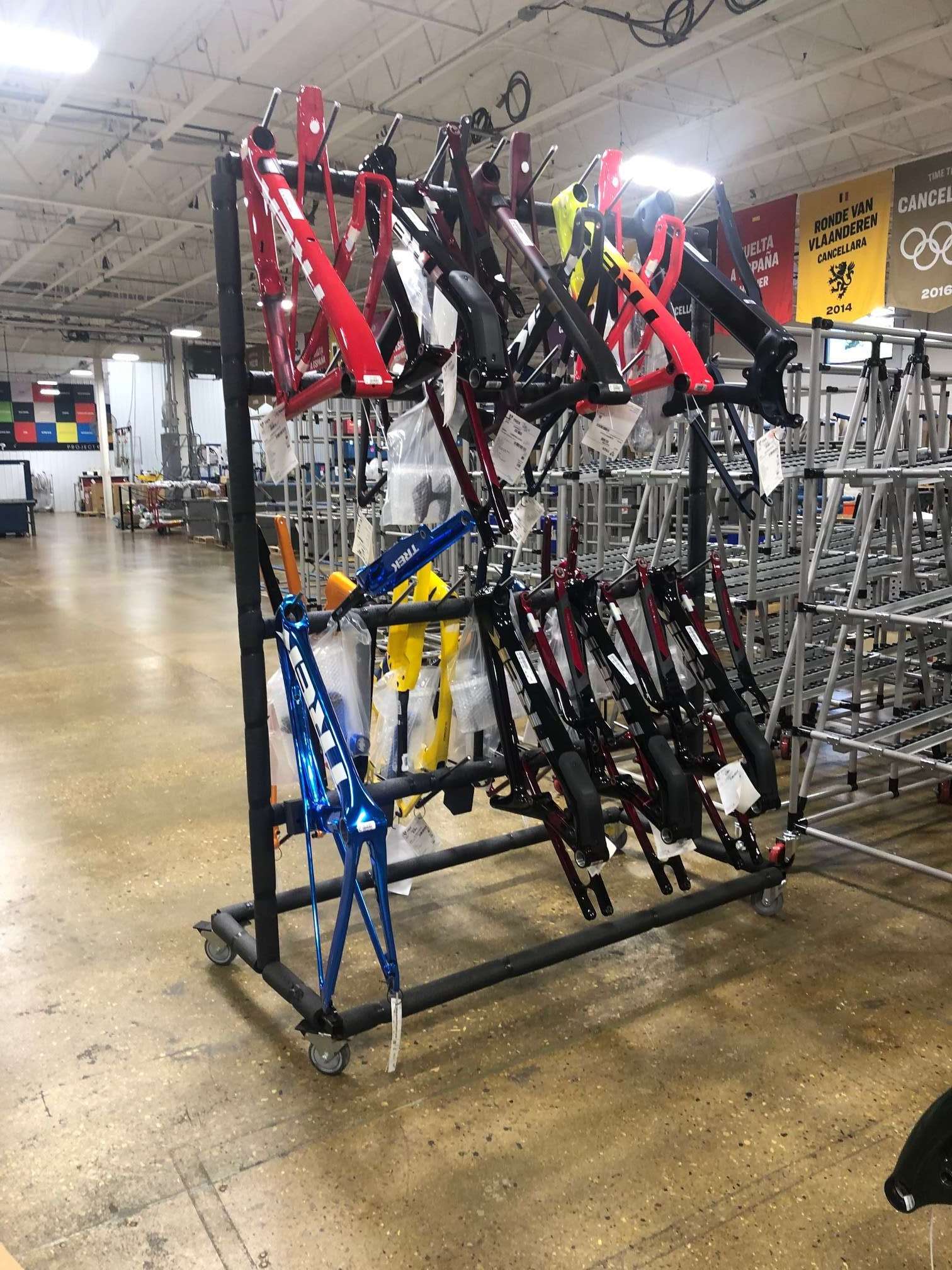 Rack holding 15 bike frames waiting to be assembled