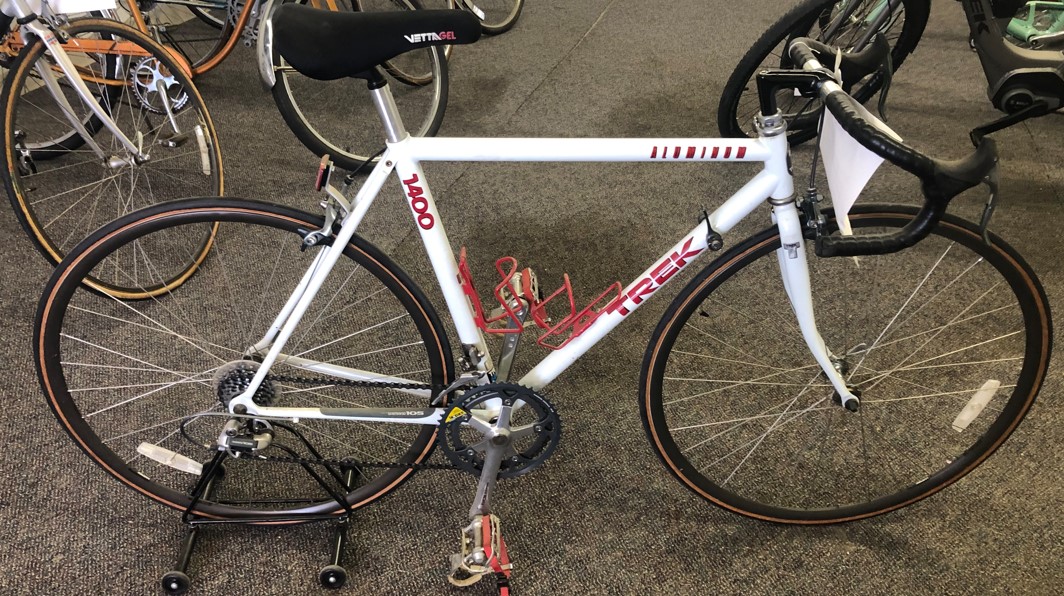 White road bike with red waterbottle holders and strap in pedals all looking good as new