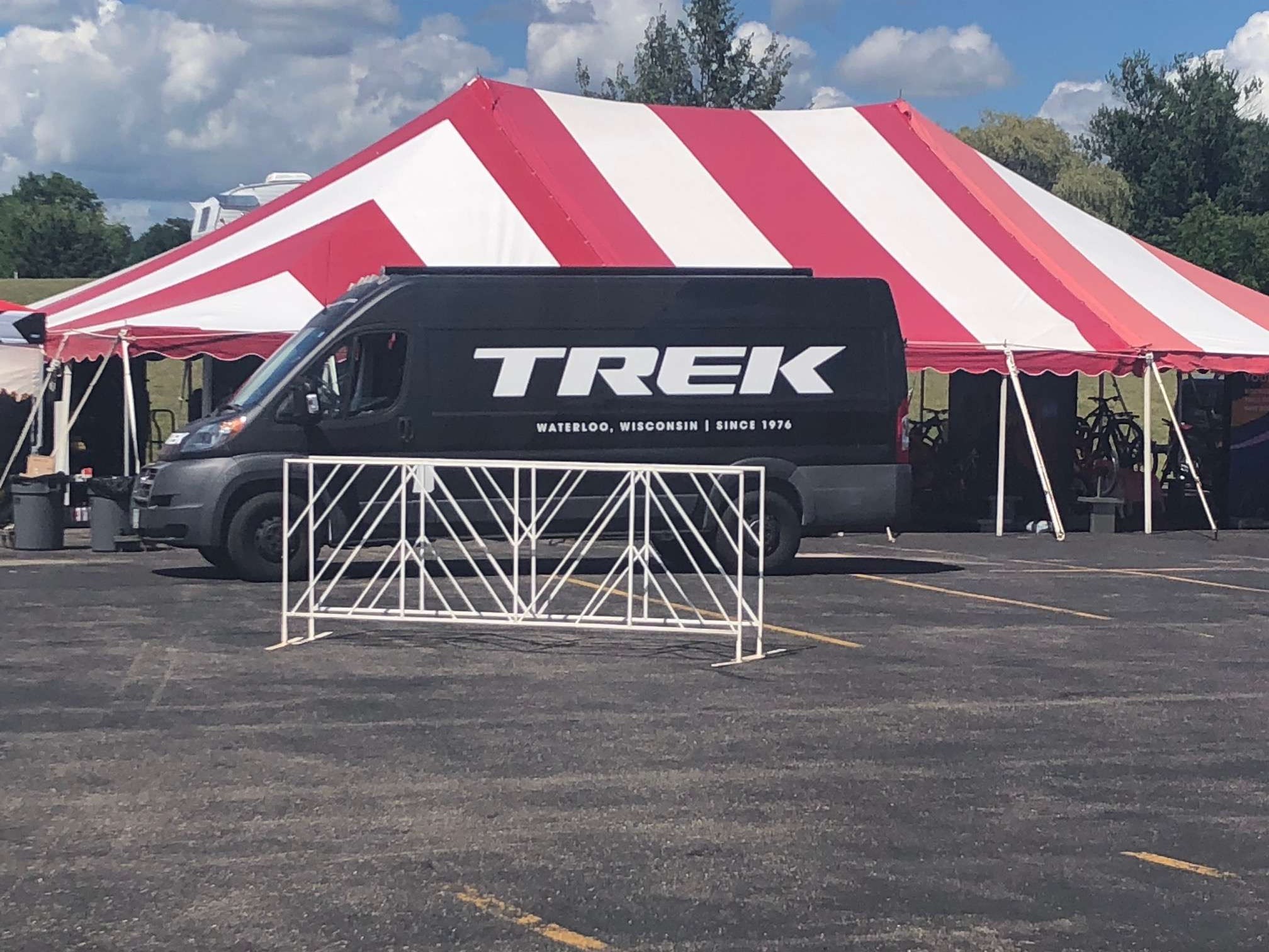 Black Trek van in front of tent as it sets up for the events