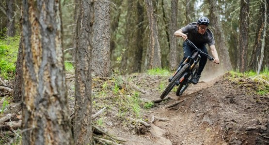 man riding electric mountain bike in the woods