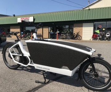 electric cargo bike with front bucket outside the store