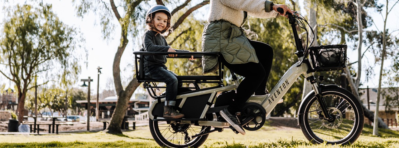Image of person riding with their child in a rear seat basket Aventon bike
