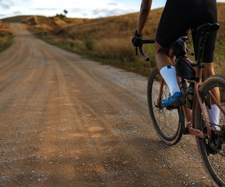 cyclist riding gravel bike on dirt road