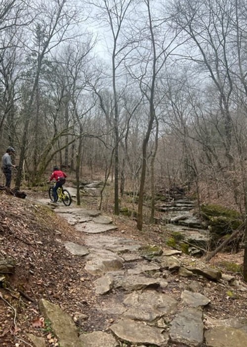 Collage with two images. Left side features a mountain biker riding on a rocky singletrack trail. On the right a mountain biker shown from a distance rides on a dirt trail.