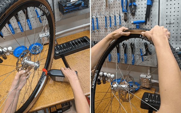 A bike mechanic pours tire sealant into the rim and pushes the remaining tire into the rim.
