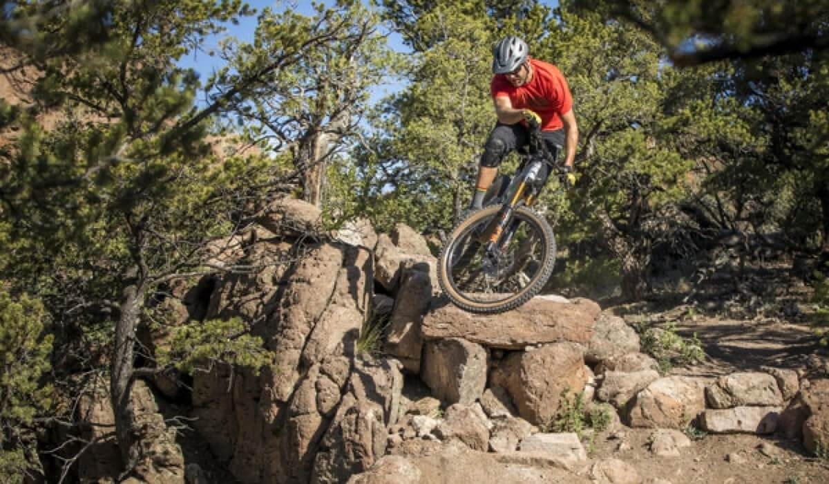Mountain biker jumps off rocky ledge on his bike featuring Kessel tires