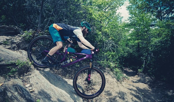 Matt Acker maneuvers his mountain bike down a steep rocky drop.