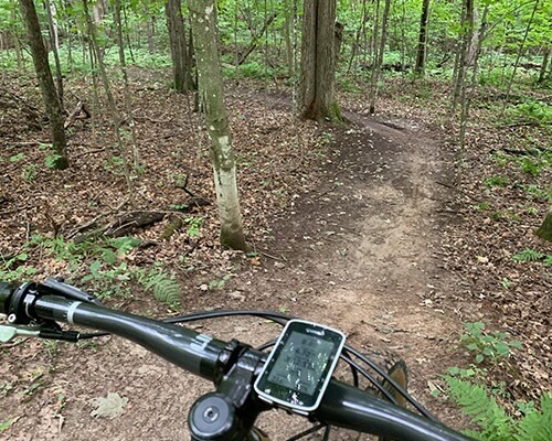 Paul's view from the handlebars which includes his bike computer and the dirt trail ahead