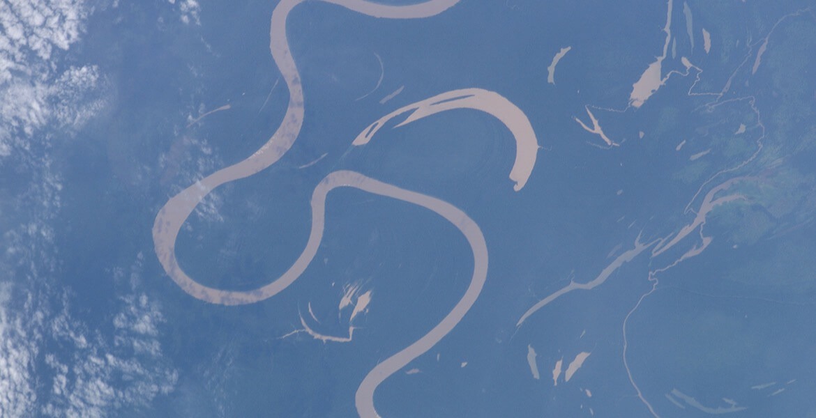 An aerial view of land and water topography with an oxbow formation