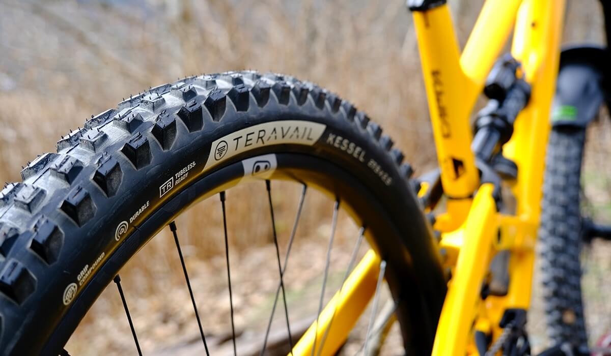Closeup of the tread and sidewall of a Teravail Kessel tire mounted on a yellow bike.