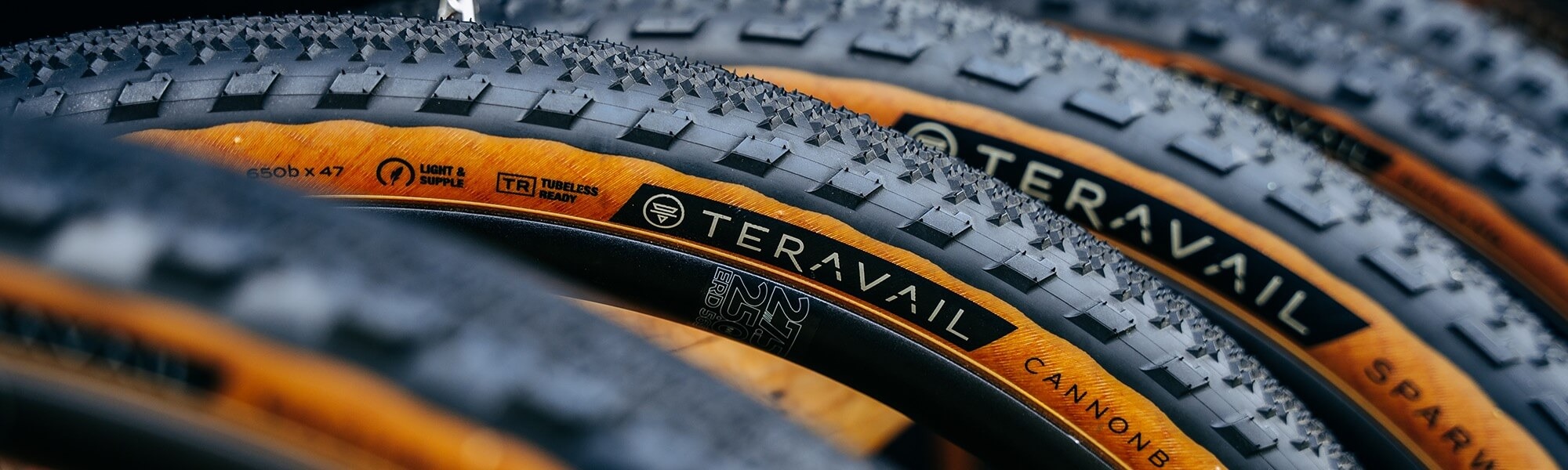 Closeup view of several bike wheels with Teravail tires on the rims with tan sidewalls