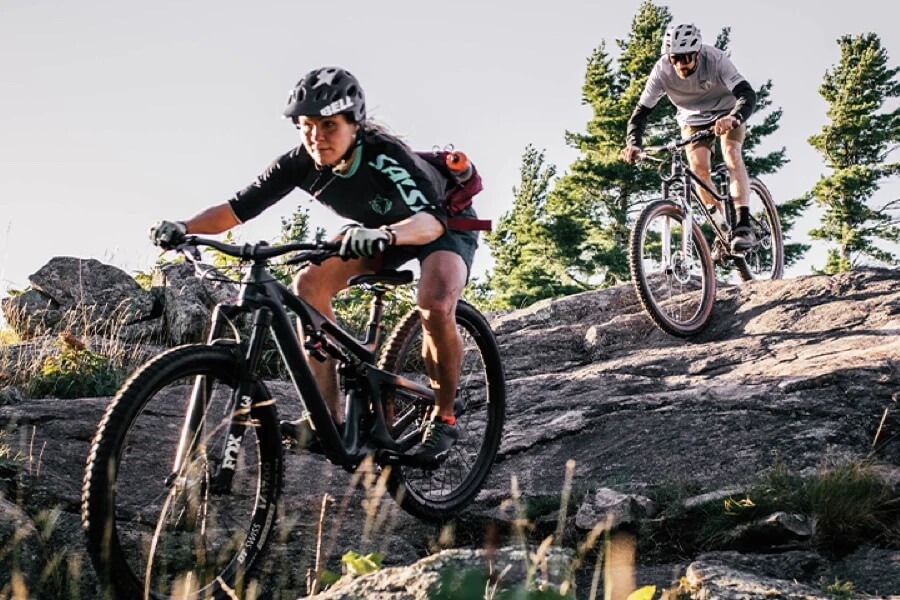 Two mountain bikers descend steep rock face