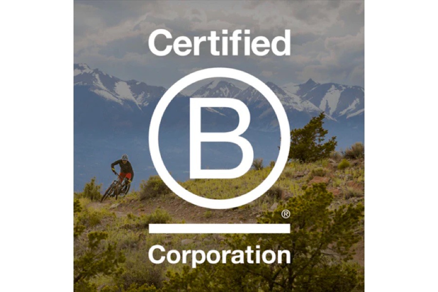 B Corp Logo is superimposed on an image of a mountain biker on a trail